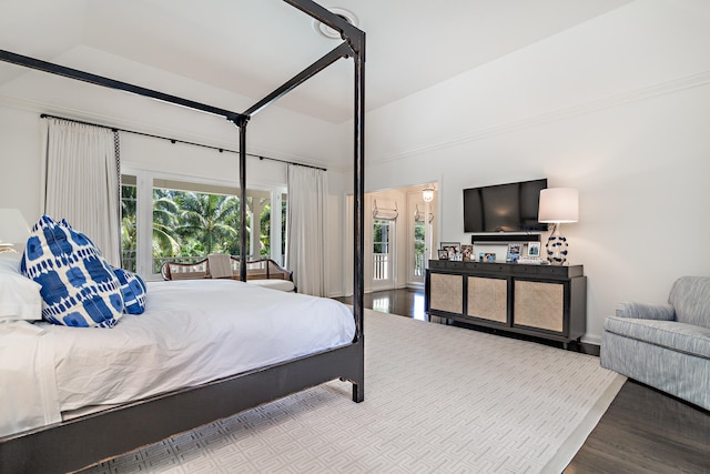 bedroom with access to exterior, light hardwood / wood-style floors, and lofted ceiling