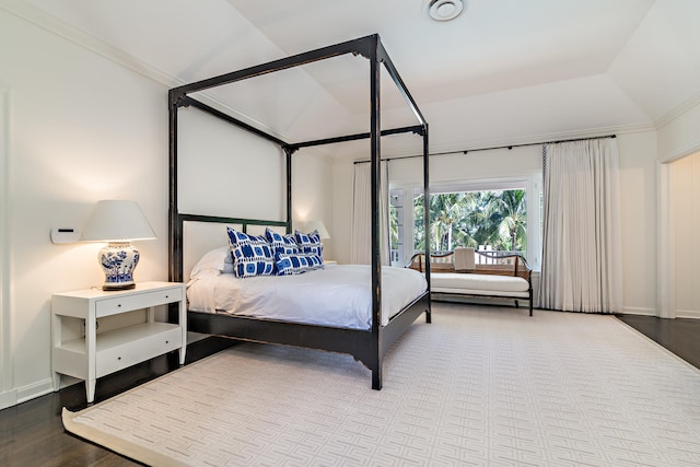 bedroom featuring lofted ceiling, wood-type flooring, and crown molding