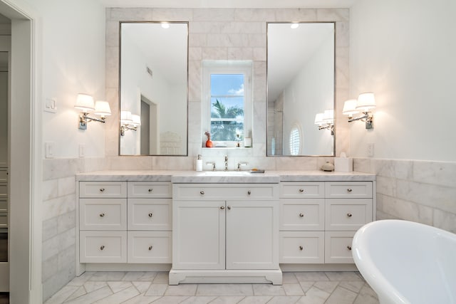 bathroom featuring a tub, vanity, and tile walls