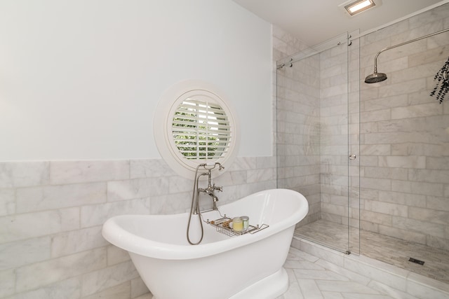 bathroom featuring separate shower and tub and tile walls