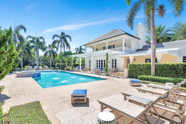 view of swimming pool featuring an in ground hot tub, pool water feature, and a patio area