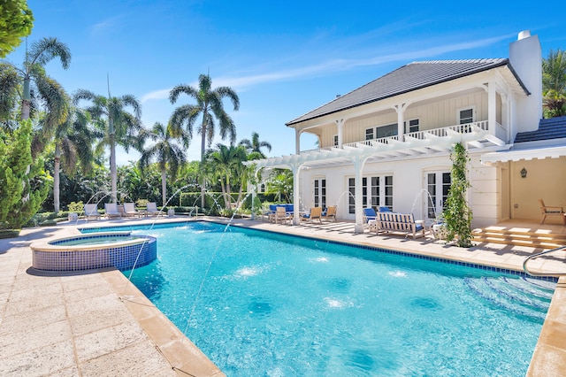 view of pool with a patio, french doors, an in ground hot tub, and pool water feature