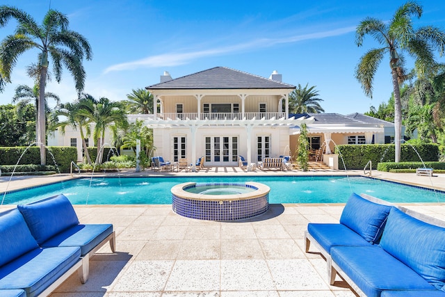 view of pool featuring outdoor lounge area, an in ground hot tub, pool water feature, and a patio area