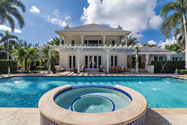 view of pool with french doors, pool water feature, a patio, and an in ground hot tub