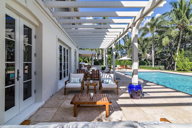 view of pool with french doors, a pergola, an outdoor hangout area, and a patio area