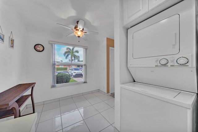 laundry area featuring ceiling fan, light tile patterned flooring, and stacked washer and clothes dryer