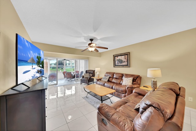 living room featuring light tile patterned flooring, a textured ceiling, and ceiling fan