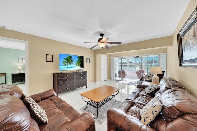 living room with ceiling fan, a textured ceiling, and light tile patterned floors