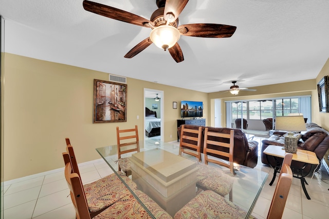 tiled dining room featuring ceiling fan and a textured ceiling