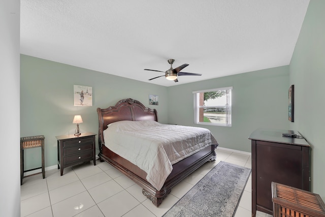 tiled bedroom with a textured ceiling and ceiling fan