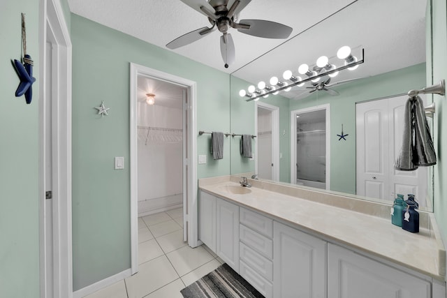 bathroom featuring a shower, vanity, a textured ceiling, and tile patterned floors