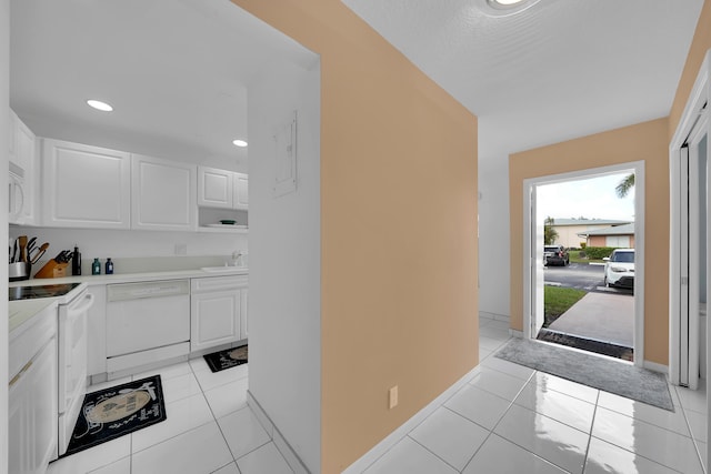 kitchen featuring white cabinetry, light tile patterned floors, white appliances, and sink