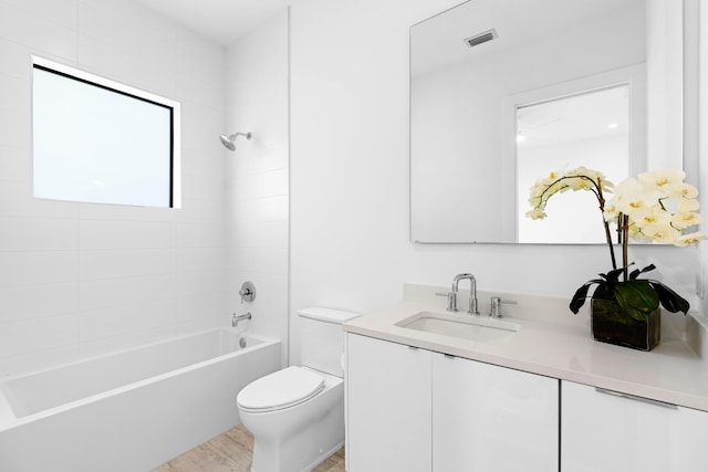 full bathroom featuring tiled shower / bath combo, toilet, wood-type flooring, and vanity