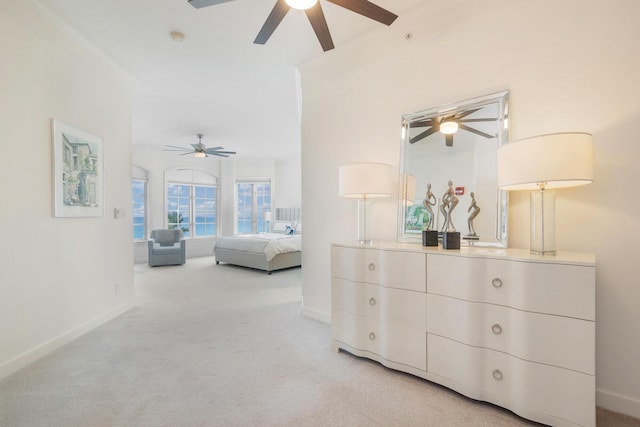 bedroom with ceiling fan, light colored carpet, and crown molding