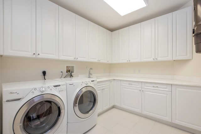 laundry area featuring cabinets, sink, and washing machine and clothes dryer