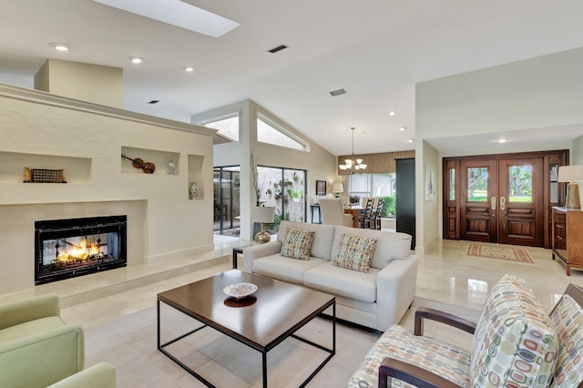 living room with a notable chandelier, light tile patterned floors, high vaulted ceiling, and french doors