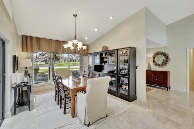 dining area with high vaulted ceiling and an inviting chandelier