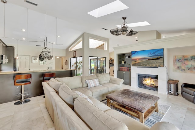 living room with high vaulted ceiling and a skylight