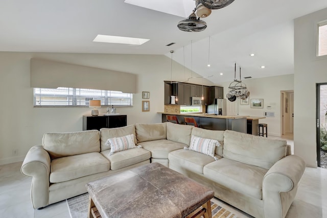 living room with vaulted ceiling with skylight