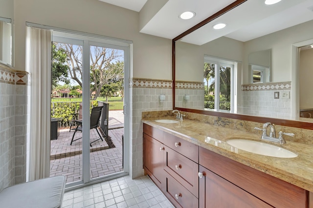 bathroom with tile patterned flooring, plenty of natural light, tile walls, and vanity