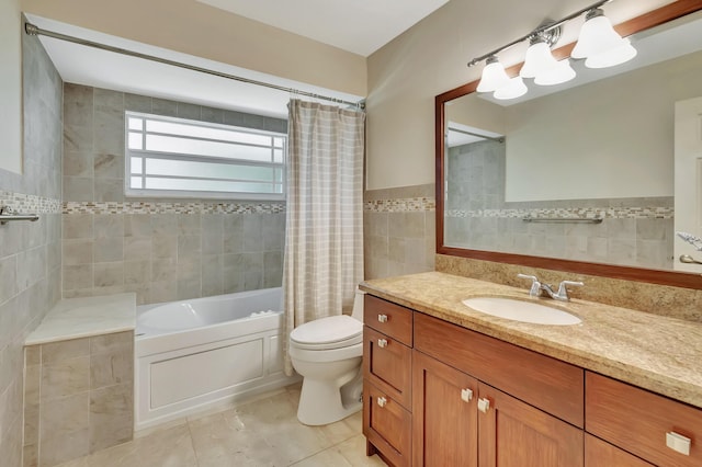 full bathroom featuring tile patterned flooring, toilet, shower / tub combo with curtain, vanity, and tile walls