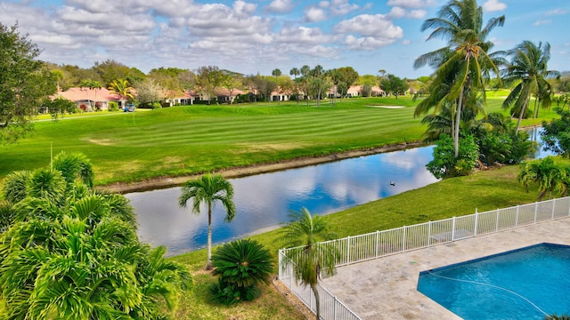 view of swimming pool with a lawn and a water view