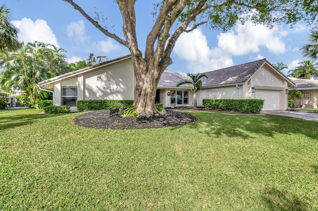 ranch-style house featuring a front lawn and a garage