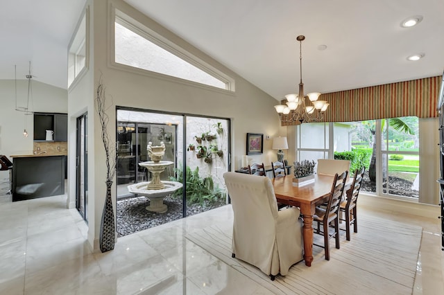 dining area with high vaulted ceiling, an inviting chandelier, and a wealth of natural light