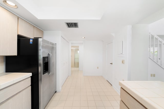 kitchen featuring tile countertops, light brown cabinets, and stainless steel refrigerator with ice dispenser