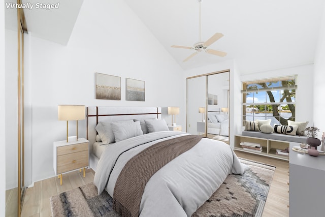 bedroom with light hardwood / wood-style flooring, high vaulted ceiling, a closet, and ceiling fan