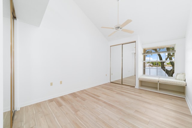 unfurnished bedroom with light hardwood / wood-style flooring, high vaulted ceiling, a closet, and ceiling fan