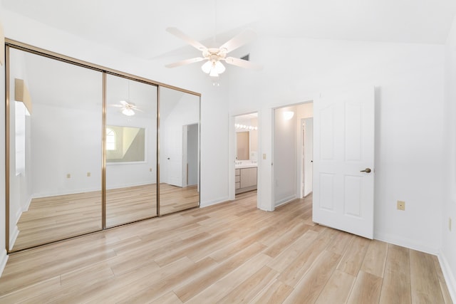 unfurnished bedroom with ensuite bathroom, a closet, lofted ceiling, ceiling fan, and light hardwood / wood-style flooring