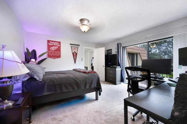 bedroom featuring ceiling fan, a textured ceiling, and light colored carpet