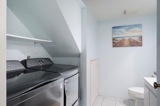 laundry room featuring independent washer and dryer and light tile patterned floors