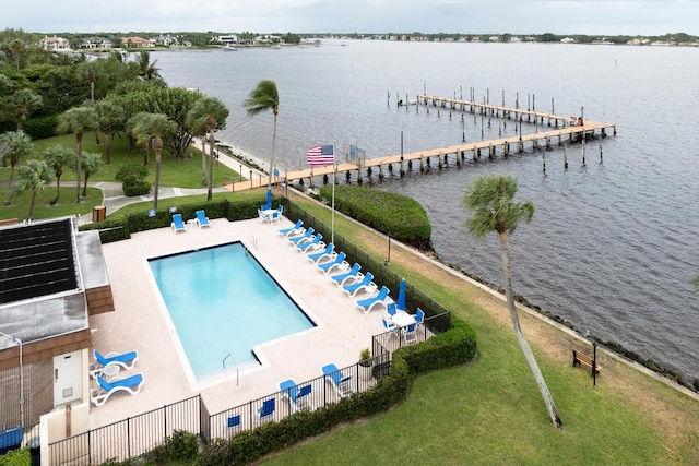 view of swimming pool with a patio area, a boat dock, and a water view