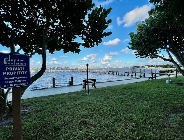 dock area featuring a water view and a yard