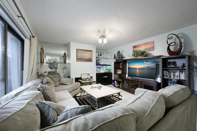 living room featuring ceiling fan and a textured ceiling