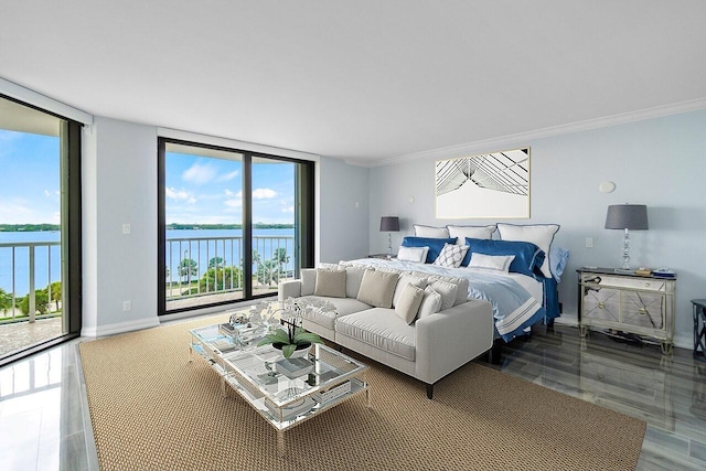 bedroom with a wall of windows, a water view, and access to exterior