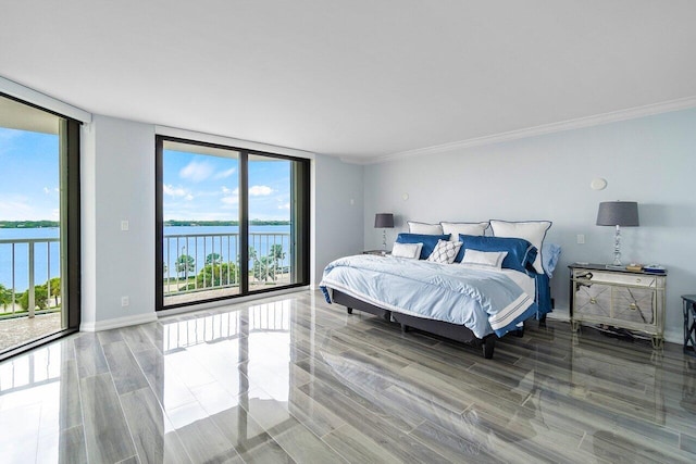 bedroom with a wall of windows, a water view, and access to exterior