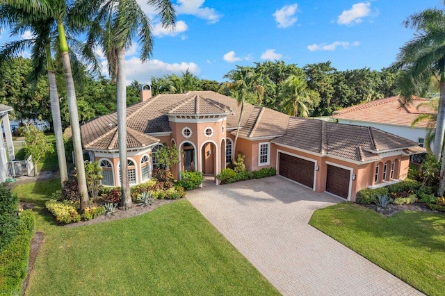 mediterranean / spanish-style home with a garage and a front yard