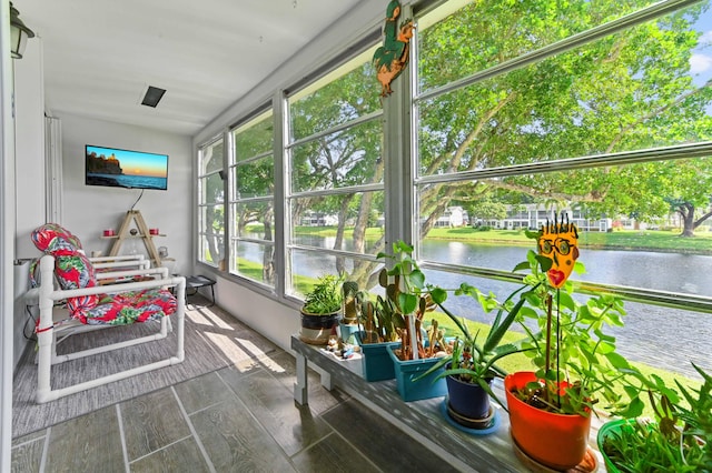 sunroom featuring a water view