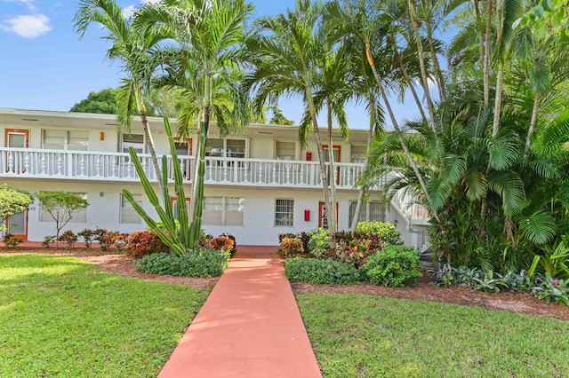 view of front of property with a balcony and a front yard