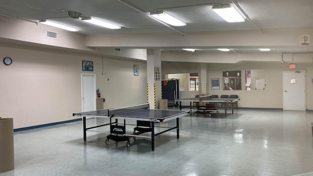 recreation room featuring a textured ceiling