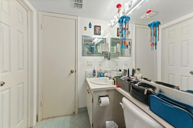 bathroom featuring toilet, vanity, and tile patterned floors