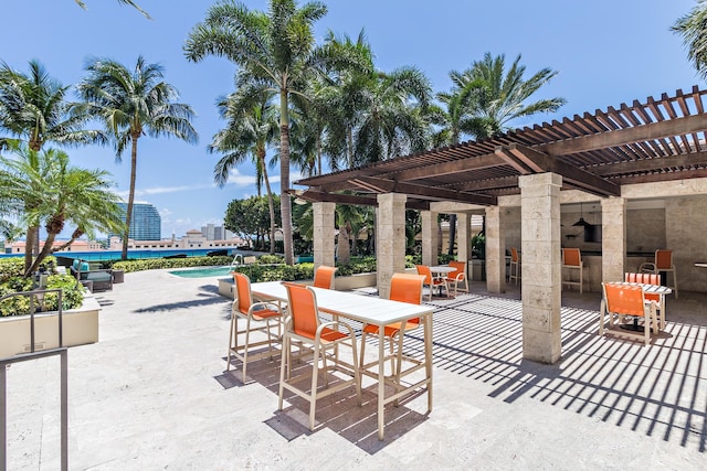 view of patio / terrace featuring exterior bar, an outdoor pool, a pergola, and outdoor dining space