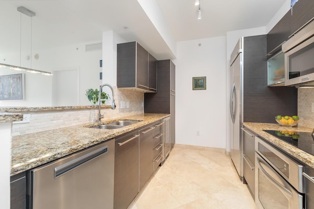 550 Okeechobee Blvd Unit 509, West Palm Beach, FL 33401 - kitchen featuring appliances with stainless steel finishes, modern cabinets, a sink, tasteful backsplash, and light stone countertops
