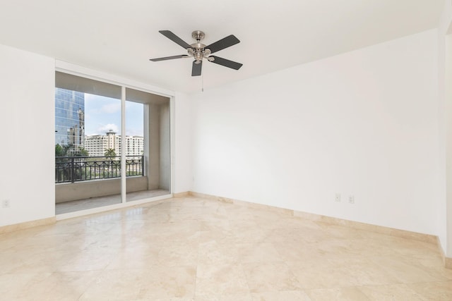 empty room with a wall of windows, baseboards, and a ceiling fan