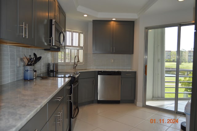 kitchen with crown molding, tasteful backsplash, stainless steel appliances, and sink