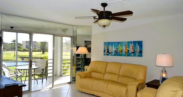 living room featuring ceiling fan, a textured ceiling, and light tile patterned floors