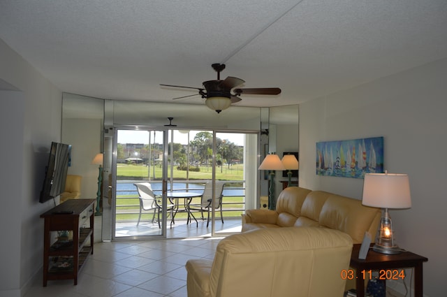 tiled living room featuring ceiling fan, a healthy amount of sunlight, and a textured ceiling